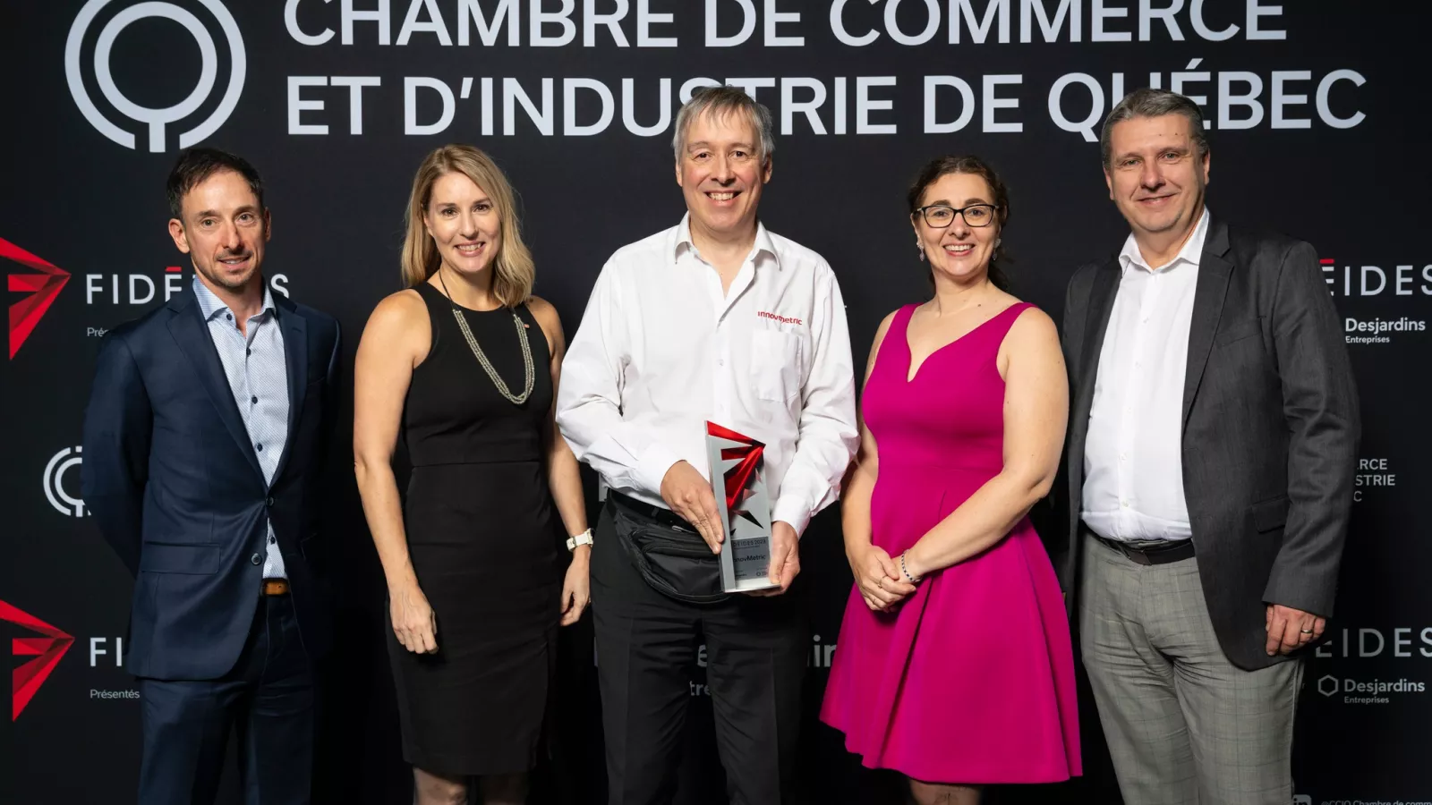 La délégation d'InnovMetric sur scène, recevant fièrement un troisième prix inattendu, le « Prix Rayonnement Hors Québec » !